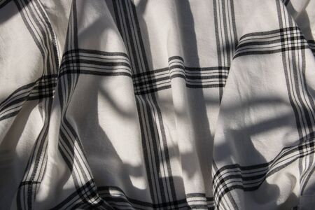 White cage cotton gentle texture clothes. Textile cloth background in sun summer day.の写真素材