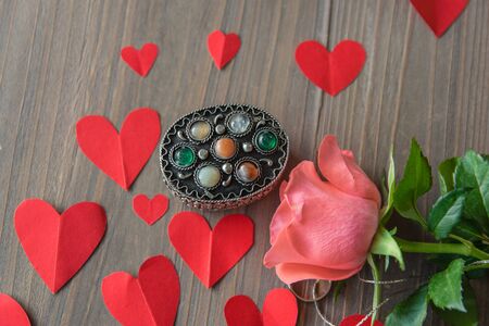 Vintage beautiful silver casket with stone, pink flower, red paper hearts. Vintage composition for Valentines Day or Womens Day. の写真素材