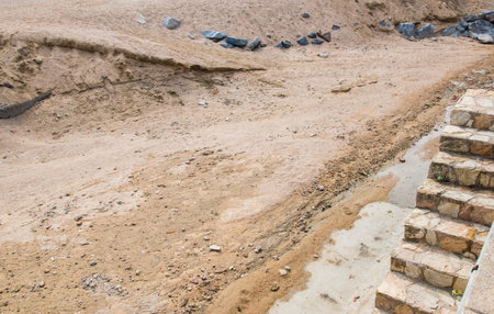 Sand, stones and ladder on the building or pit in Spain. Nature texture and grit in summer sun day.