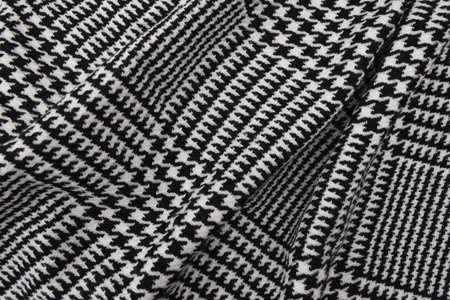 Black and white cage texture fabric. Winter cashmere scarf. Textile warm dark knitted cloth...