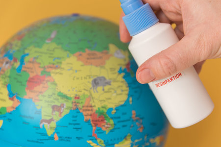 Globus and antibacterial spray, hand sanitizer on the beige background.