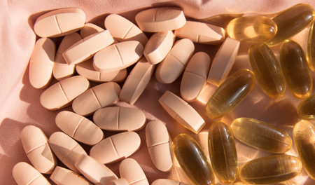 Vitamins and omega 3 fish oil on the natural wood background with pink silk fabric in summer day.
