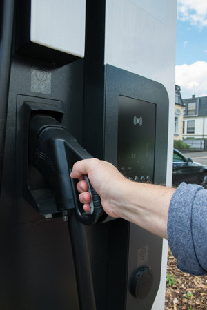 Hand holding gas pump in gas tank. Fuel, oil, gas filling - close up gas or electric station.