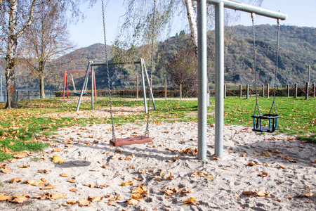 Empty playground for children near the river. Swings, sands for play in autumn time.の写真素材
