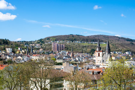 Beautiful city panorama with houses, river, vineyards, viewed from above surrounded by mountains in summer time.の写真素材