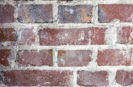 Gray structural stone wall of the ancient building consists of old dark bricks. Nature structural...