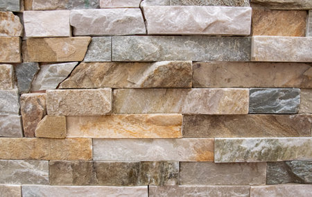 Beautiful beige structural stone wall of the ancient building consists of small bricks. Natural...