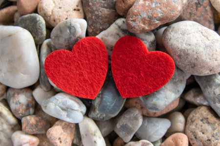 Two beautiful red fabric heart on the a lot of stones near the river.の写真素材