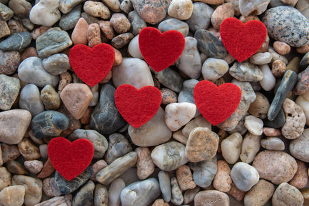 Red bright fabric heart on other stones near the river.の写真素材