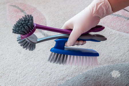 Hand in rubber glove with brushes. Plastic big brush for cleaning on the floor. House cleaning...