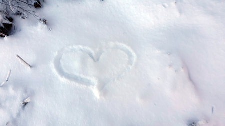 Heart, the love sign, on a snow covered in the winter time. Romantic background.の写真素材