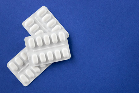 Medical pills and drugs in white package on the blue background. Healthcare concept. Space for text.の写真素材