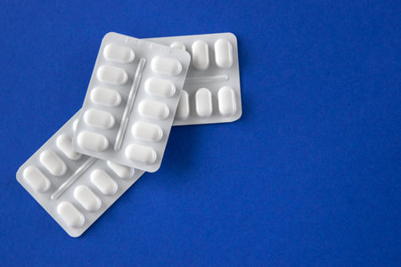 Much medical pills and drugs in white package on the blue background. Healthcare concept. Space for...