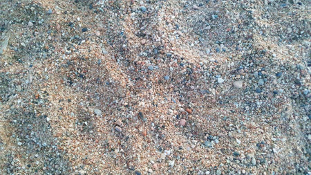 Much stones on the sand near the water. Sea beach. Nature background.の写真素材