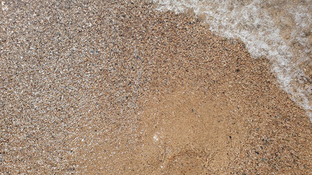 Much sand and water in the sun weather. Walking on the sea beach.の写真素材