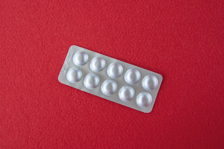 Much medical pills and drugs in white package on the red background. Healthcare concept. Space for...