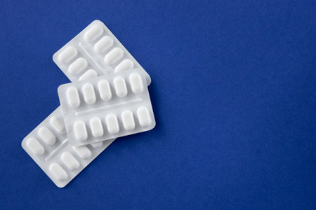Much medical pills and drugs in white package on the dark blue background. Healthcare concept. Space...