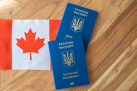 Ukrainian passport on the Canadian flag background. Travel, business or emigration.の写真素材