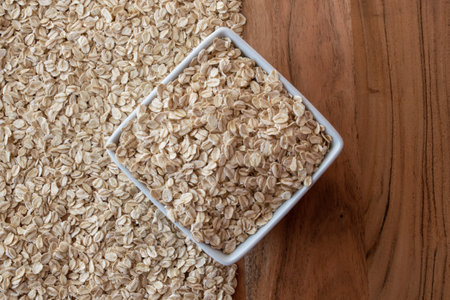 Dry oat flakes in white porcelain plate for healthy breakfast on the wood table.の写真素材