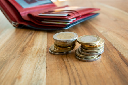 Coins stack on the wood table near the red leather wallet. Wallet with european money for commerce business concept.の写真素材