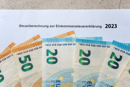 Paper form for tax return in 2023 year. EinkommensteuererklÃ¤rung and income in euro money bills. Steuer in Germany.の写真素材