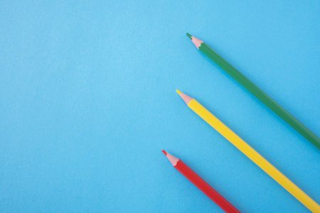 Three pencils red, yellow, green on the bright blue background. Traffic light colors. Close up. Design concept. Space for text.の写真素材