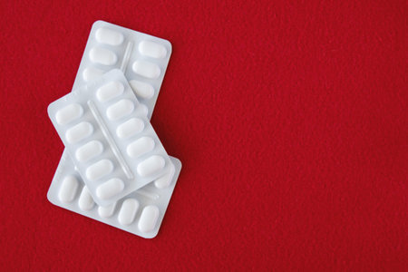 Much medical pills and drugs in white package on a red background. Healthcare concept. Space for...