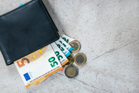 Black partmone with euro money. Coins and bills in leather wallet for commerce concept. Space for...