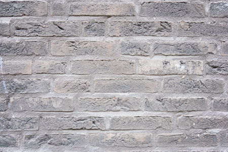 Gray structural stone wall of the ancient building consists of bricks. Nature structural background.