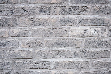 Gray structural stone wall of the ancient building consists of bricks. Nature cement structural background.の写真素材
