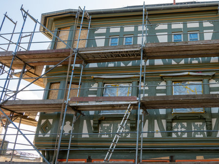 Scaffold on the old germany building for renovation. Repair facade of historical house with green ornament.の写真素材