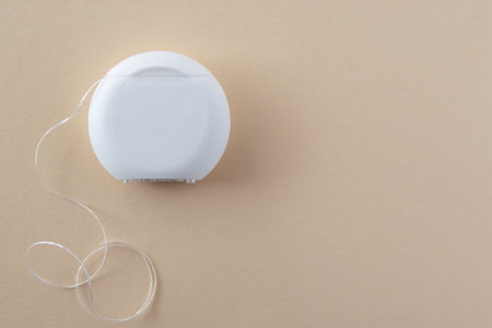 White dental floss for mouth hygiene and health teeth on the beige background. Space for text.の写真素材