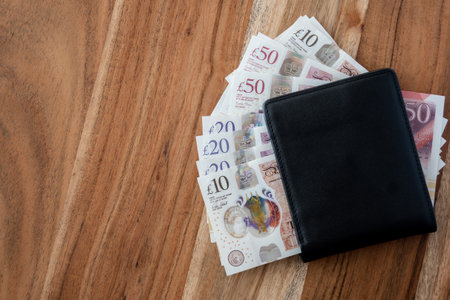 Black partmone with British pound money. United Kindom bills in leather wallet for commerce concept.の写真素材