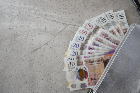 Black partmone with British pound money. United Kindom bills in leather wallet for commerce concept.の写真素材