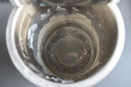 Black electric teapot with limescale surface. Hard water in metal kettle in the kitchen.の写真素材