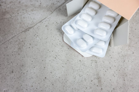 White pills and drugs in cardboard on the nature stone background. Healthcare concept. Space for...