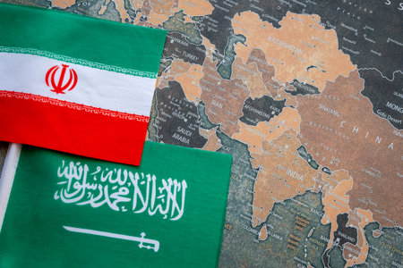 National flag of Iran and Saudi Arabia on the world map background.