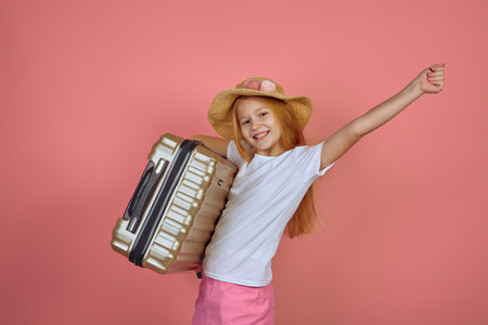 Redhead smiling teen girl holding suitcase wearing hat. Luggage, travelling, vacation.の写真素材