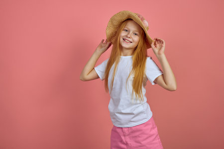 Teen redhead smiling girl on pink background with hat.の写真素材