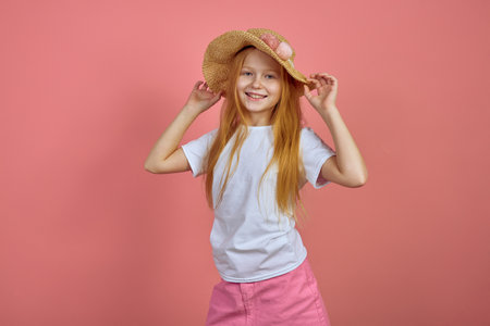 Teen redhead smiling girl on pink background with hat.の写真素材
