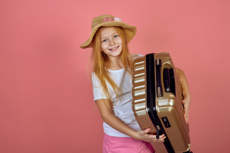 Redhead smiling teen girl holding suitcase wearing hat. Luggage, travelling, vacation.の写真素材
