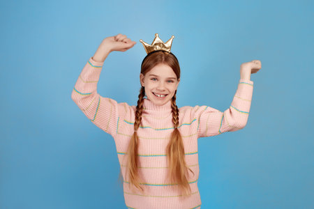 Little surprised girl with golden crown on blue background.の写真素材