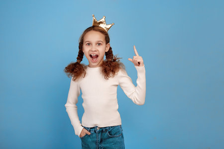 Happy little African-American girl with crown on blue background.の写真素材