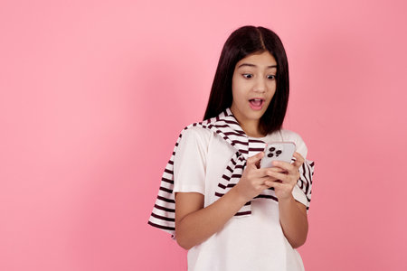 Young shocked teenage girl with bag on pink background in studio.の写真素材