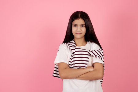 Young angry teenage girl on pink background in studio.の写真素材