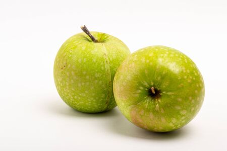 Two green ripe apple close up on a white backgroundの写真素材