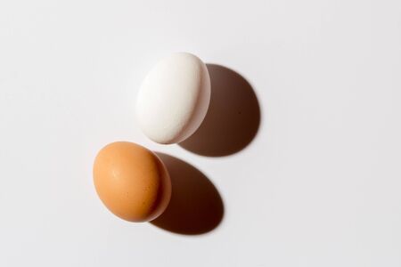 Two chicken eggs lie on a White background. Top viewの写真素材