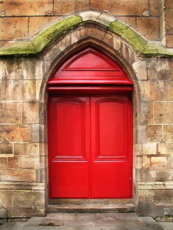 Red wooden doors, renovated, of the old stone cathedral. の写真素材