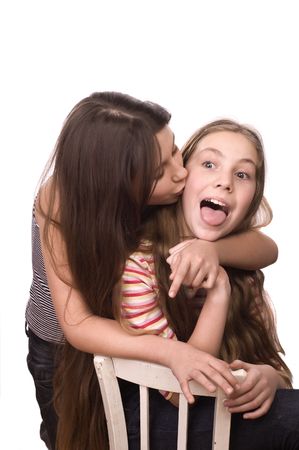 Two girls in the age of ten and eleven embracing and fooling isolated on whiteの写真素材