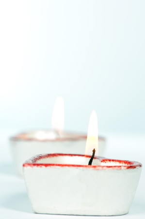 Two white and red heart-shaped candles tinted blueの写真素材